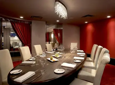 a dining room with a long wooden table and white chairs at Sterling Inn & Spa in Niagara Falls