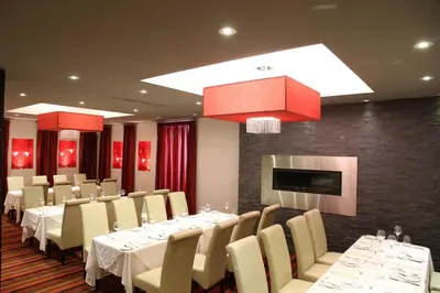 a dining room with white tables and chairs and a tv at Sterling Inn & Spa in Niagara Falls