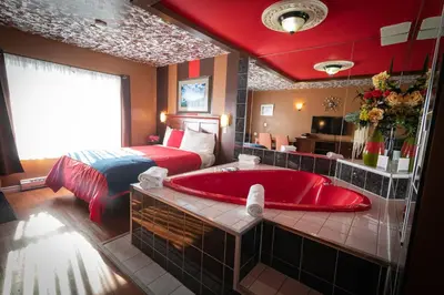 a bedroom with a bed and a red bath tub at Villager Lodge Niagara Falls in Niagara Falls
