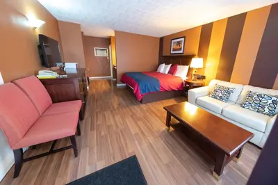 a hotel room with a couch and a bed at Villager Lodge Niagara Falls in Niagara Falls