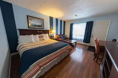 a bedroom with a bed and a desk with a chair at Villager Lodge Niagara Falls in Niagara Falls