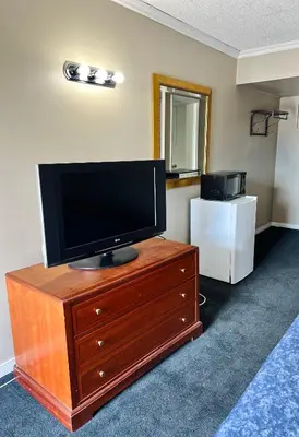 a flat screen tv sitting on top of a dresser at Fairway Inn by the Falls in Niagara Falls