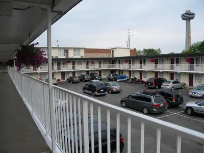 a parking lot with cars parked in front of a building at Fairway Inn by the Falls in Niagara Falls