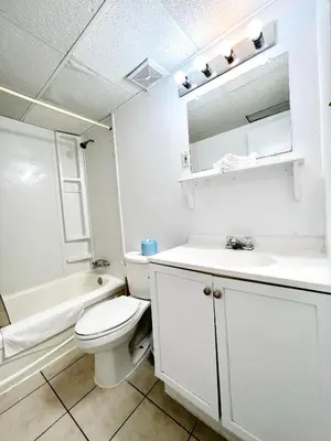 a white bathroom with a toilet and a sink at Fairway Inn by the Falls in Niagara Falls