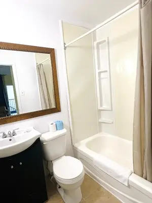a bathroom with a toilet and a sink and a tub at Fairway Inn by the Falls in Niagara Falls