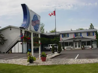 a building with a canadian flag in a parking lot at Blue Moon Motel in Niagara Falls