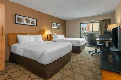 a hotel room with two beds and a television at Comfort Inn in Pickering