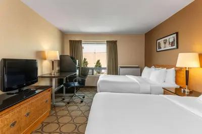 a hotel room with two beds and a flat screen tv at Comfort Inn in Pickering