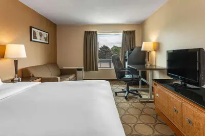 a hotel room with a bed and a flat screen tv at Comfort Inn in Pickering