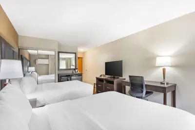 a hotel room with two beds and a desk with a computer at Comfort Inn in Burlington