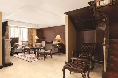 a room with chairs and a living room with a fireplace at Radisson Hotel Toronto Airport West in Mississauga