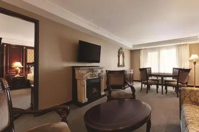 a living room with a fireplace and a dining room at Radisson Hotel Toronto Airport West in Mississauga