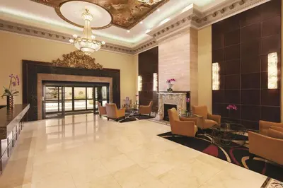 a lobby with a fireplace and chairs and a chandelier at Radisson Hotel Toronto Airport West in Mississauga
