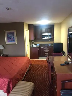 a hotel room with a bed and a kitchen at Niagara Lodge & Suites in Niagara Falls