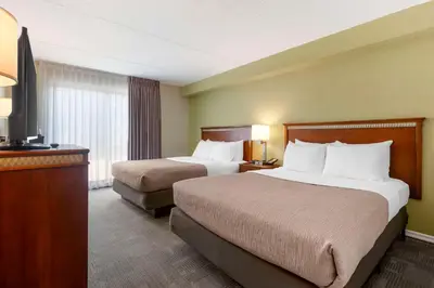 a hotel room with two beds and a television at Quality Inn in Peterborough