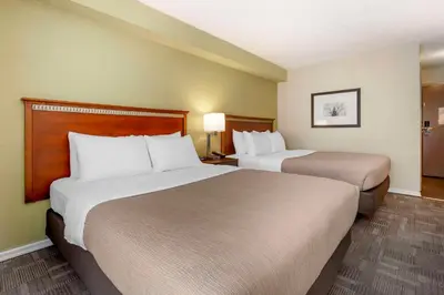 a hotel room with two beds and two lamps at Quality Inn in Peterborough