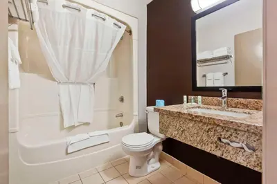a bathroom with a toilet and a sink and a tub at Quality Inn in Peterborough