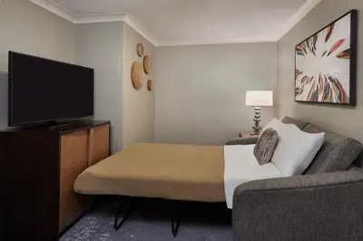 a room with a bed and a couch and a television at The Westin Trillium House, Blue Mountain in Blue Mountains
