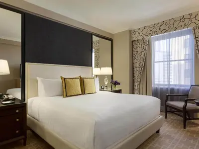 a bedroom with a large white bed and a chair at Fairmont Royal York Hotel in Toronto