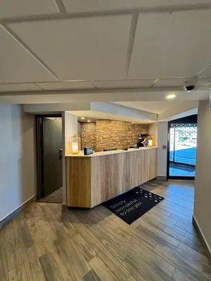 an office lobby with a counter and a brick wall at Spark by Hilton Oshawa in Oshawa