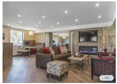 a living room with a couch and a fireplace at Spark by Hilton Oshawa in Oshawa