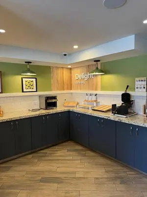 a large kitchen with blue cabinets and green walls at Spark by Hilton Oshawa in Oshawa