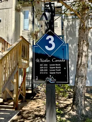 a sign on a pole in front of a house at Mountain Side Condo Loft at The Blue Mountains in Blue Mountains