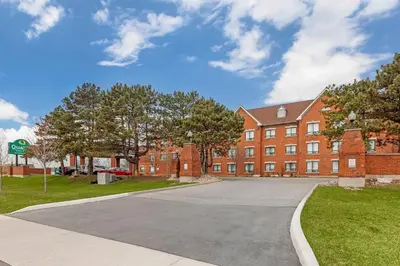 an empty street in front of a brick building at Quality Suites in Whitby