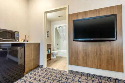a large flat screen tv on the wall of a hotel room at Quality Suites in Whitby
