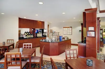 a restaurant with tables and chairs and a counter at Staybridge Suites Oakville Burlington by IHG in Oakville