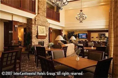 a hotel dining room with tables and chairs at Staybridge Suites Oakville Burlington by IHG in Oakville