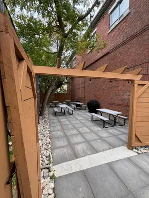 a wooden pergola with benches and tables on a patio at Comfort Suites in London