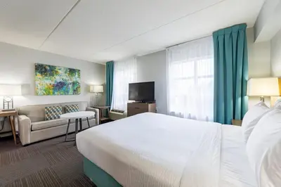 a hotel room with a bed and a couch at Staybridge Suites Guelph by IHG in Guelph