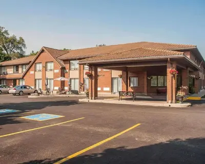 a building with a bench in front of a parking lot at Comfort Inn in Orillia