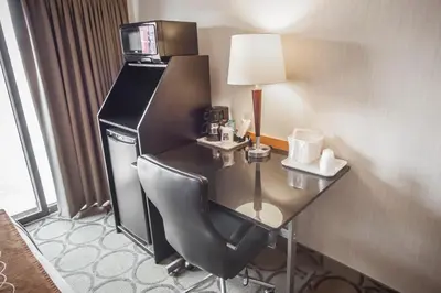 a desk in a hotel room with a table and chair at Comfort Inn in Orillia