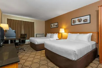 a hotel room with two beds and a flat screen tv at Comfort Inn in Orillia