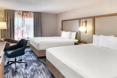 a hotel room with two beds and a desk and a chair at Fairfield Inn & Suites by Marriott Toronto Brampton in Brampton