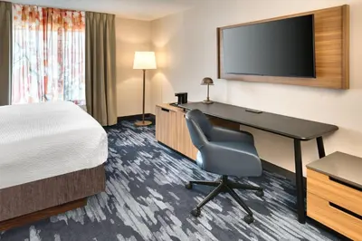 a hotel room with a desk and a bed and a television at Fairfield Inn & Suites by Marriott Toronto Brampton in Brampton