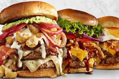 two hamburgers with cheese and vegetables on buns at Holiday Inn Toronto Airport East by IHG in Toronto