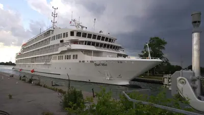 a large cruise ship is docked in the water at The White House Boutique B&B in Niagara on the Lake