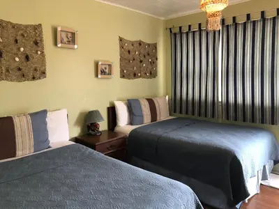 a bedroom with two beds and a table with a lamp at The Rex Motel At Niagara Falls in Niagara Falls