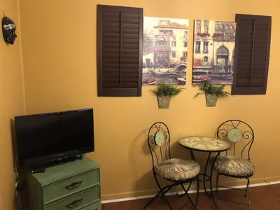 a living room with a table and two chairs and a tv at The Rex Motel At Niagara Falls in Niagara Falls