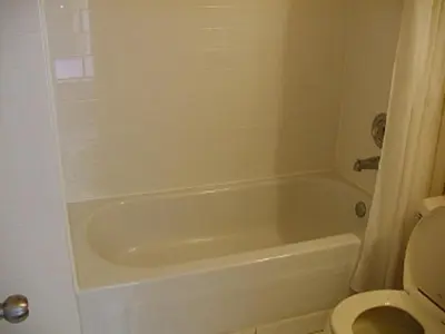 a bathroom with a white tub and a toilet at Niagara Inn & Suites in Niagara Falls