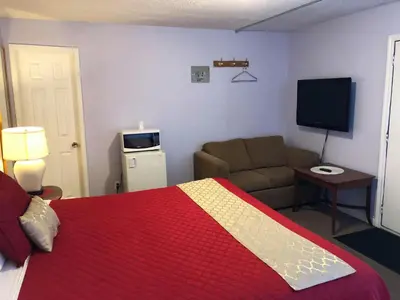 a bedroom with a bed and a couch and a television at Niagara Inn & Suites in Niagara Falls