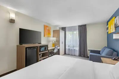 a hotel room with a bed and a flat screen tv at Comfort Inn in St. Catharines