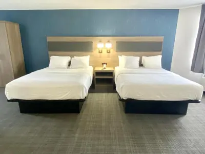 a hotel room with two beds and a table at Comfort Inn in St. Catharines