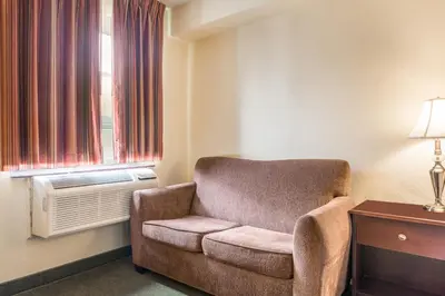 a chair in a room with a window at Knights Inn Orillia in Orillia