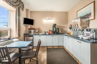 a kitchen with a table and a counter top at Knights Inn Orillia in Orillia