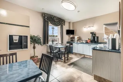 a kitchen and dining room with a table and chairs at Knights Inn Orillia in Orillia