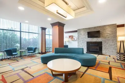a living room with a couch and a fireplace at Fairfield Inn & Suites by Marriott Toronto Airport in Mississauga